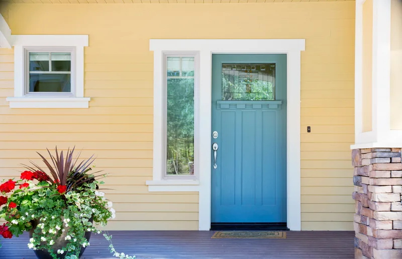 A sunny porch with a bright front door
